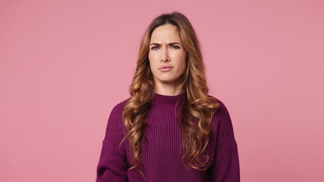 Young woman wear purple knitted casual clothes showing finger gesture no I do not need it pointing thumb down dislike gesture isolated on plain pastel light pink background studio. Lifestyle concept