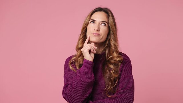 Excited smart proactive young woman wear purple knitted casual clothes look around think scratches at temple comes up with idea raised finger get plan isolated on plain pastel light pink background
