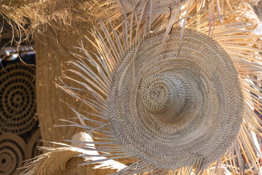 A market stall in Spain selling traditional handicrafts made from natural fibers, esparto grass: woven bags, hats and decorative sculptures, including esparto cacti, showcasing artisanal craftsmanship