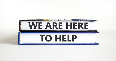 Support, help and we are here to help symbol. Concept words We are here to help on beautiful books. Beautiful white paper background. Business we are here to help concept. Copy space.
