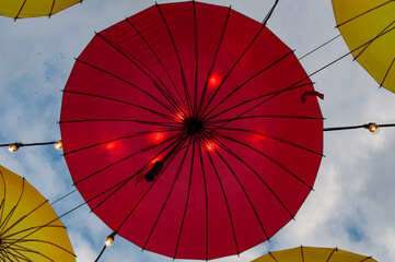 Fototapeta premium Street decorations in the form of suspended umbrellas illuminated by LED lamps