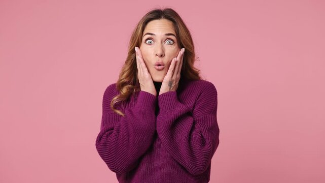 Side profile view surprised young woman wear purple knitted sweater casual clothes turn around camera cover mouth with hands on face say wow omg no way isolated on plain pastel pink pink background