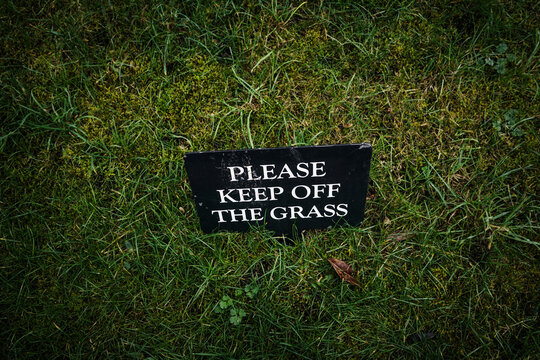 'Please keep off the grass' sign on the grass. Close up. 