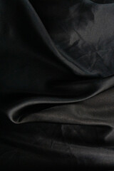 Fototapeta premium black silk texture background dark wavy surface elegant cloth fabric folds luxury material drapery smooth textile backdrop with copy space for banner design concept of fashion, interior design, luxury