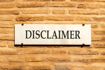 Disclaimer symbol. Concept word Disclaimer on beautiful white marble sign plate. Beautiful ancient brick wall background. Business disclaimer concept. Copy space.