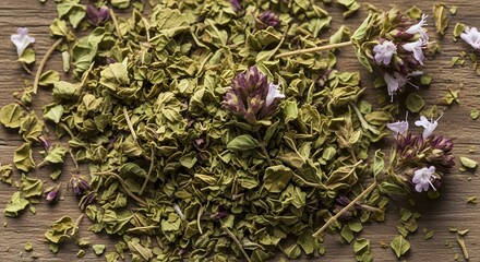 Close up of dried oregano leaves and flower buds on wooden surface