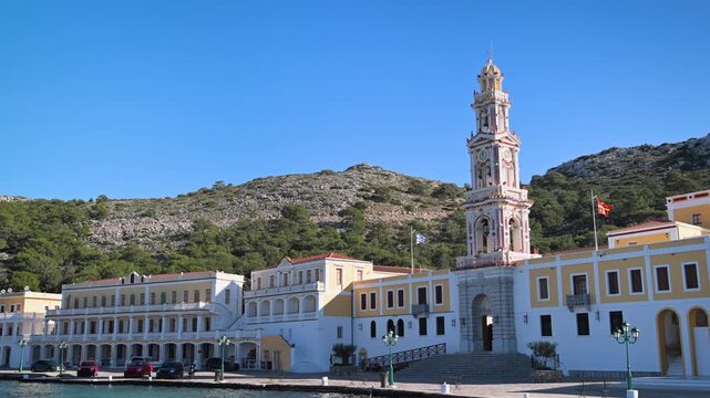 Facade of Panormitis Monastery Against Blue Sky and Hills on Symi Island, Greece