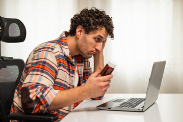 Confused and worried man about his health issue, using laptop and searching for advice on Internet...