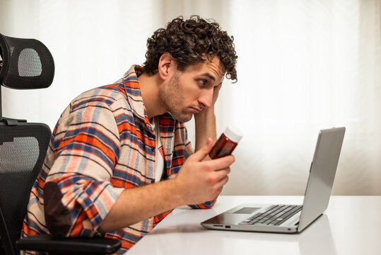 Confused and worried man about his health issue, using laptop and searching for advice on Internet while sitting at his home.	