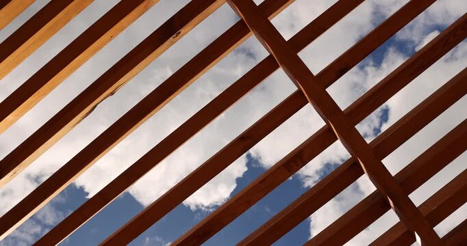 a wooden frame made of planks on the beach in sunny weather against a blue sky with clouds, part of a wooden frame building under construction on the beach to create a good infrastructure
