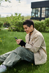 Obraz premium Young woman enjoys a sunny day outdoors in stylish jacket with smartphone