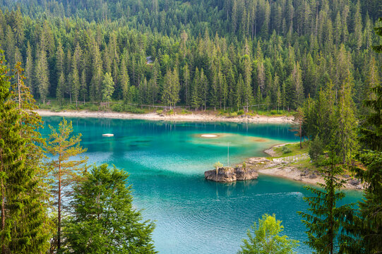 View of Cauma Lake Caumasee with crystal blue turquoise water and rocky beach in beautiful mountain landscape with pine forest, Flims, Graubuenden, Switzerland.