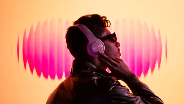 Vibrant mixed media portrait man enjoying music with pink sound waves. Concept of personal audio experience, modern lifestyle, emotional connection, streaming culture and creative digital expression.