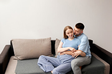 Obraz premium Couple sitting together on a sofa, enjoying each others company in a cozy indoor setting during the afternoon