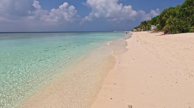 Empty white sand beach in Ukulhas Maldives with palm trees and turquoise water
