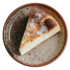 Cheesecake slice on spotted plate, browned top, powdered sugar, overhead view