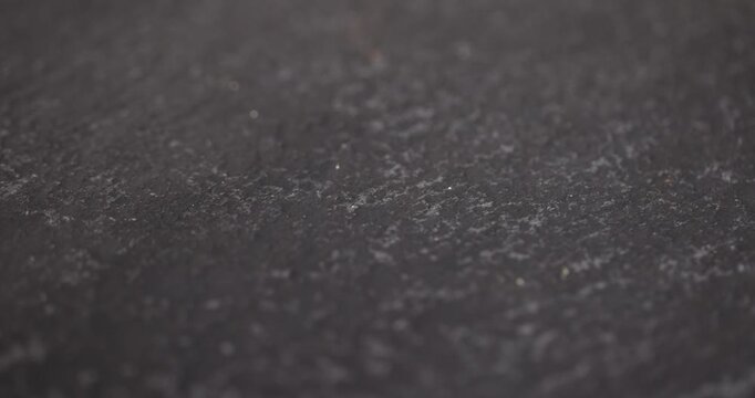 wet black and embossed black slate for serving, covered with lots of water drops kitchen board made of black embossed slate