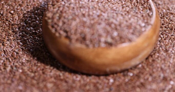 a round wooden bowl completely filled with flax seeds, which can be used both for nutrition and for obtaining a new crop