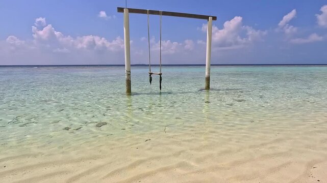 Empty white sand beach in Ukulhas Maldives with palm trees swings and turquoise water