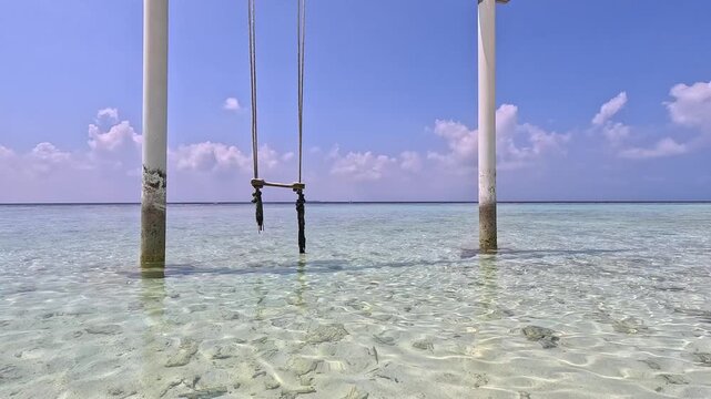 Empty white sand beach in Ukulhas Maldives with palm trees swings and turquoise water