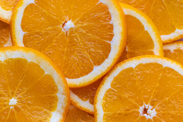 Fresh orange slices stacked on a flat surface with bright colors in the kitchen setting during daytime