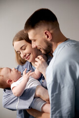 Fototapeta premium Loving parents joyfully interacting with their newborn baby in a cozy home environment, showcasing the beauty of family bonding and nurturing moments, family love concept