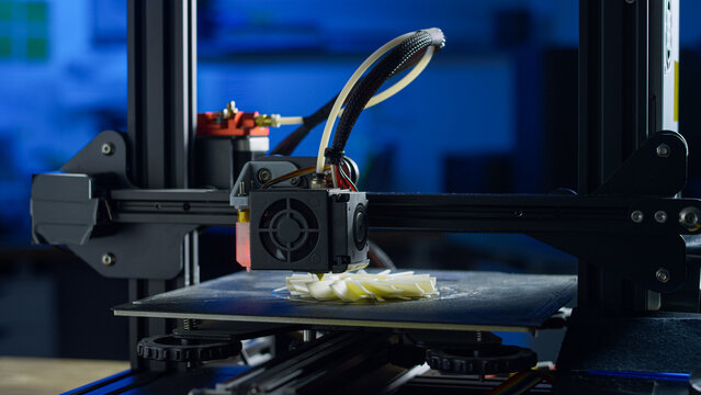 A 3D printer creates a plastic prototype using additive manufacturing in a clean and organized workspace with no human presence.