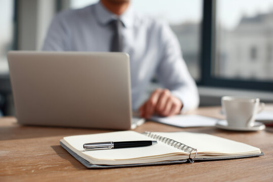 business man organized workspace with notebook and planning tools, laptop, paper notebook, pen
