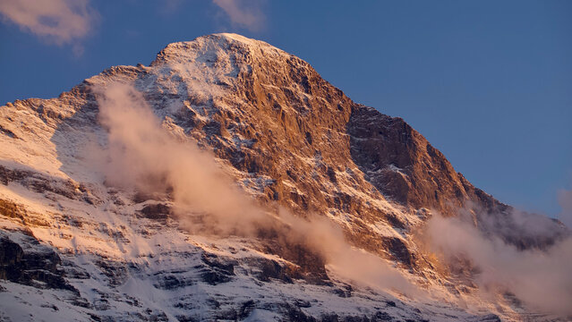 Eiger North Face in the Swiss Alps at sunset with atmospheric clouds