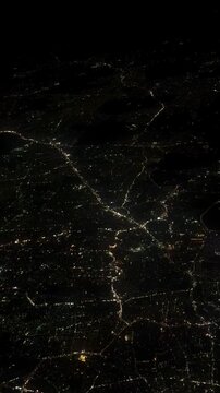 aerial night view of city lights forming glowing network patterns on dark landscape