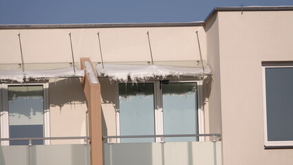 Sople lodu zwisające z dachu nad balkonem © tomo81