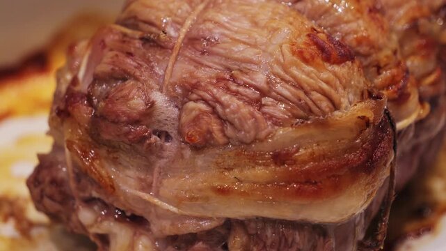 Close-up of juicy tasty grilled roast beef in baking dish. Roasted meat close-up.