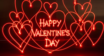 Happy Valentine's Day neon light lettering with glowing red heart shapes on dark background for romantic celebration and greeting cards.