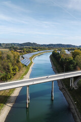 Aerial view of solar panels by a river highlights clean energy and environmental responsibility.