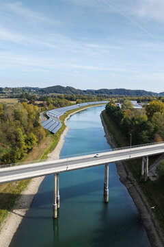 Aerial view of solar panels by a river highlights clean energy and environmental responsibility.