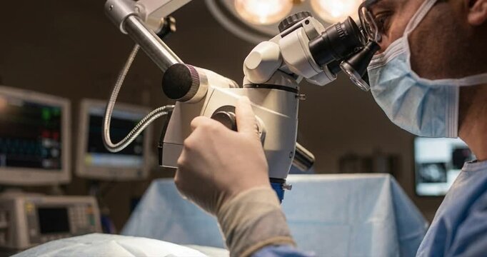 Medical professional using surgical microscope during procedure