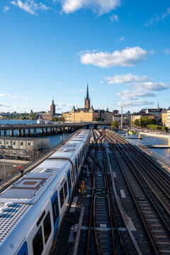 Stockholm Sweden railway tracks perspective shows train transport corridor through urban skyline with converging lines and blue sky