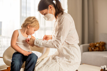 Fototapeta premium Little toddler boy, getting injection in consulting room from pediatrition