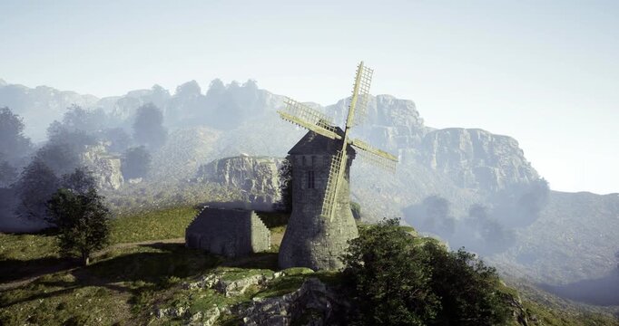 A rustic windmill stands proudly on a green hillside, surrounded by trees and rocky terrain. Mountains rise majestically in the background under a clear sky.