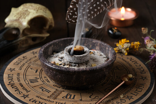 Close-up of a Wicca incense ritual &ndash; spreading sacred smoke with a feather