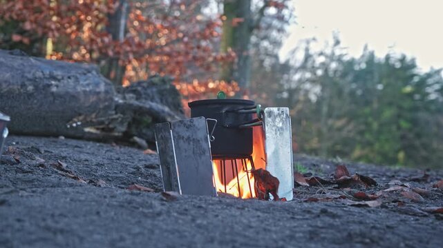 Water Boiled in Metal Cup on Improvised Hiking Buddy Burner Stove Covered from Wind with Folding Windshield