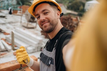Making a selfie. A builder is working at the construction site at daytime