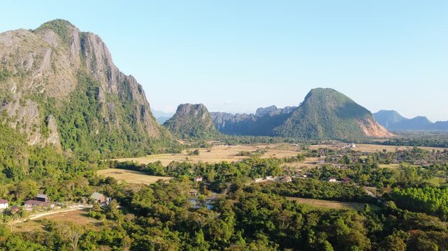 Aerial perspective of majestic limestone karst mountains and tropical jungle with dracaenas and cycas in Vang Vieng, Laos