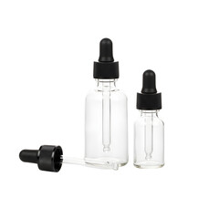 Clear glass dropper bottles with black caps and separate pipettes on a reflective white background, ideal for cosmetic packaging, essential oil containers, and medical laboratory serum mockups.