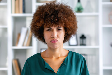 Young offended African American woman pouts lips to show displeasure or resentment