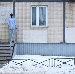 The mannequin is standing on the porch steps