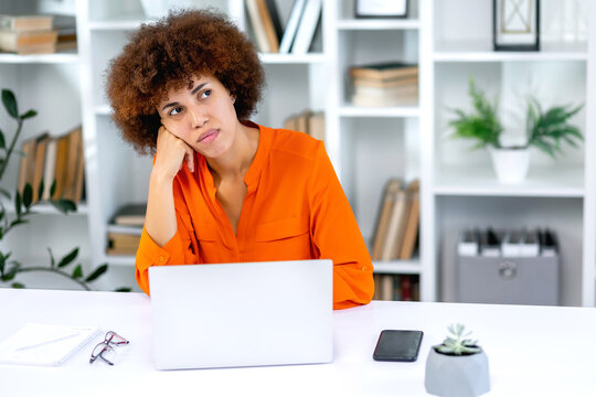 Bored young woman sit at home office table look in distance unable to work at laptop, exhausted girl student feel unmotivated unwilling to study, distracted taking break. Dull monotonous job concept