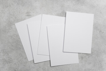 Stack of blank white cards on grey concrete background with copy space for greeting cards, wedding...