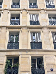 Facades of beautiful old buildings with French windows and shutters, Paris, France.