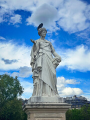 The statue "Comedy" shows muse of comedy Thalia, which holds a comic mask in her hands, the Tuileries Gardens, Paris, France.